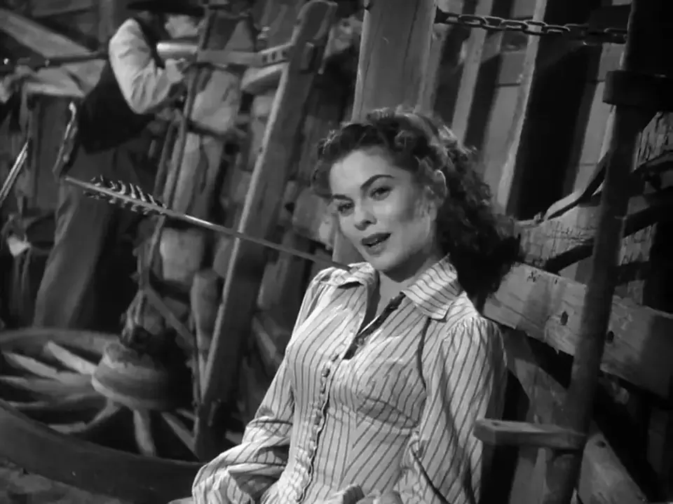 A woman sat against some timbers, an arrow sticking out of her shoulder